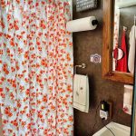 Decorative shower curtain hides stuff stored in the shower